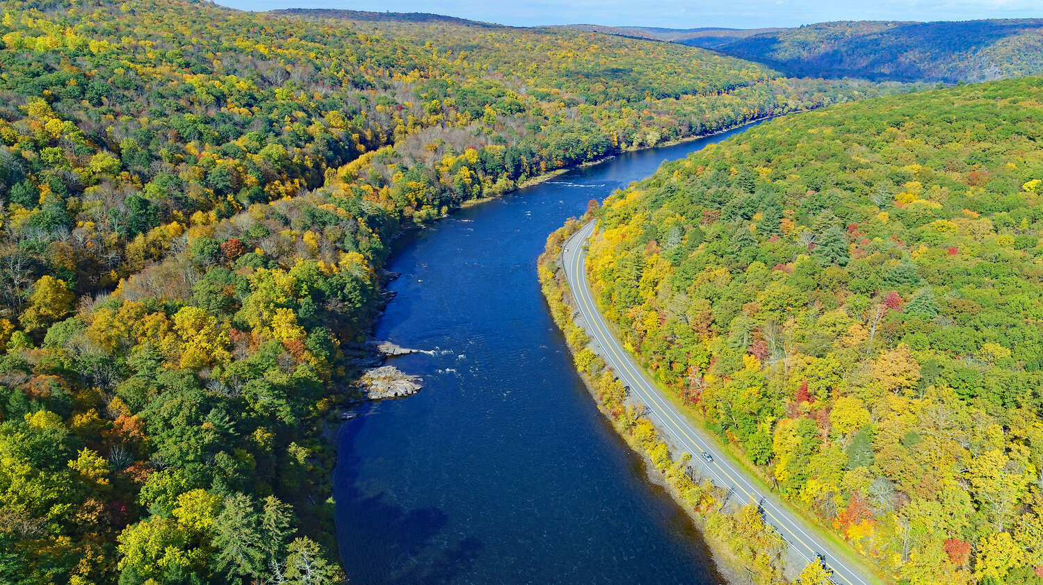 Here is an aerial view looking upstream towards Staircase Rapids on the Delaware River. The Delaware River valley is one of the lowest-lying areas in the region; the fall foliage can be a few days behind the mountain tops due to the lower elevation. ..Paddling the river is a great way to see the fall foliage. Be prepared for cooler weather and cooler water temperatures, and please wear your lifejacket. ....